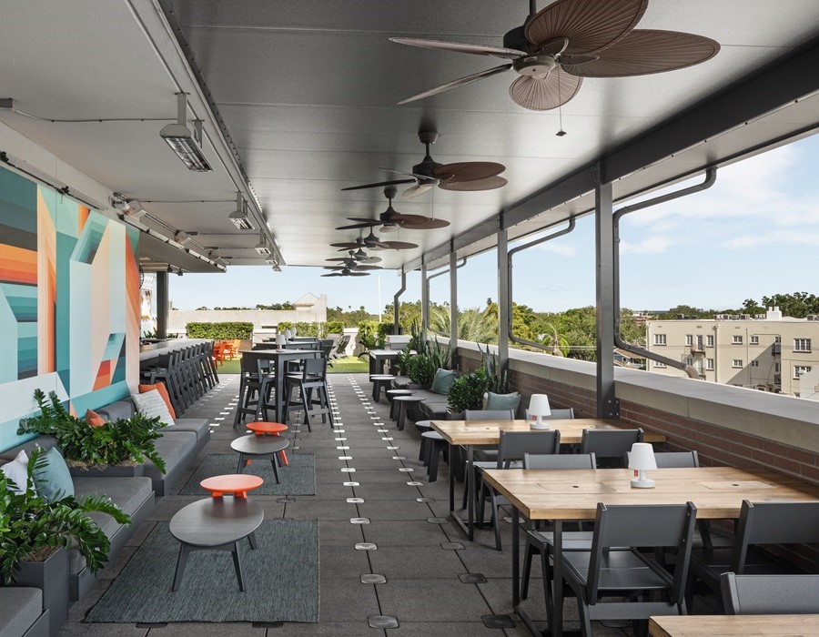 A room with tables and chairs and city view at Edge Rooftop Bar in Hyde Park FL at Epicurean Hotel