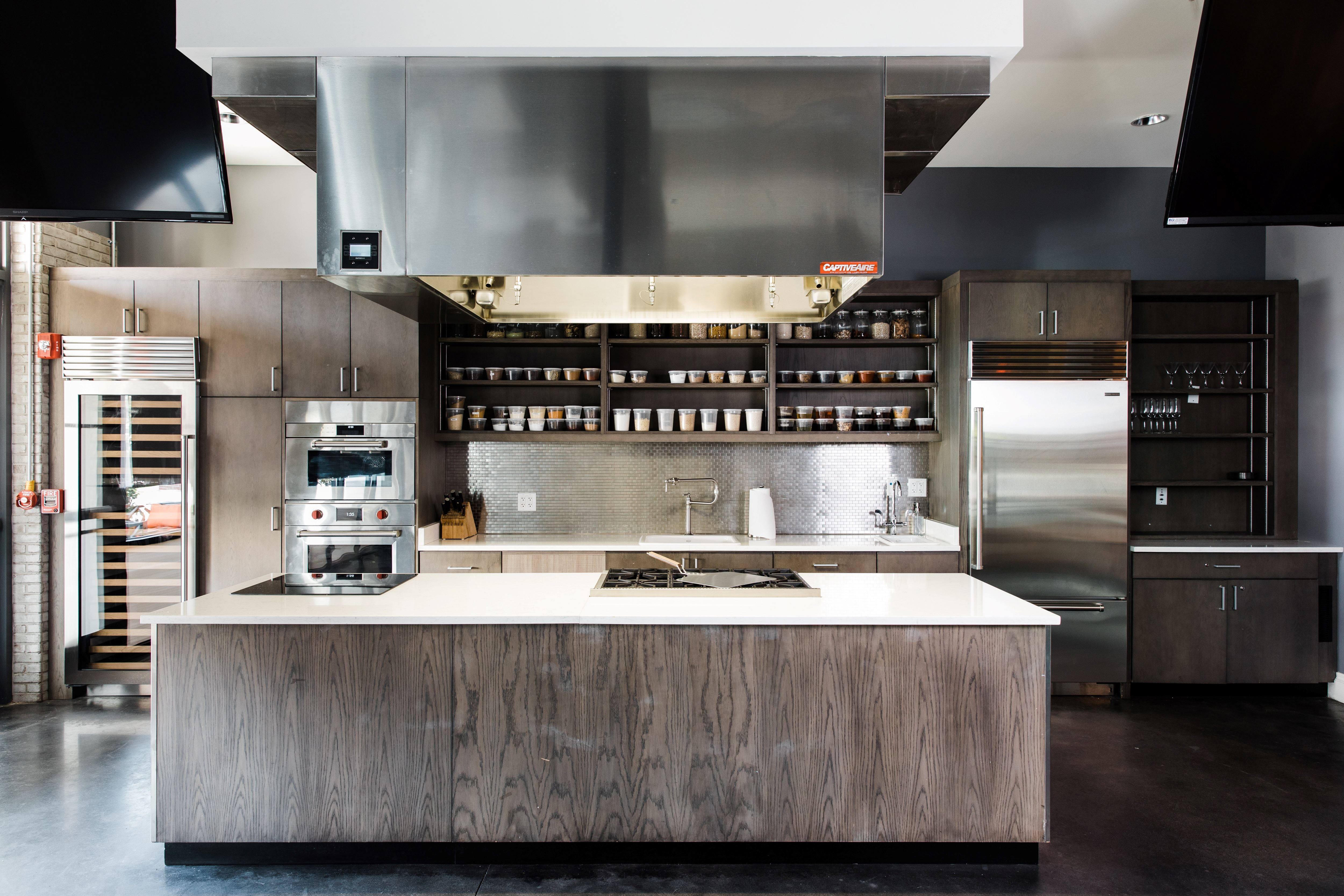 A kitchen with stainless steel appliances in the Epicurean Theatre in Epicurean Hotel