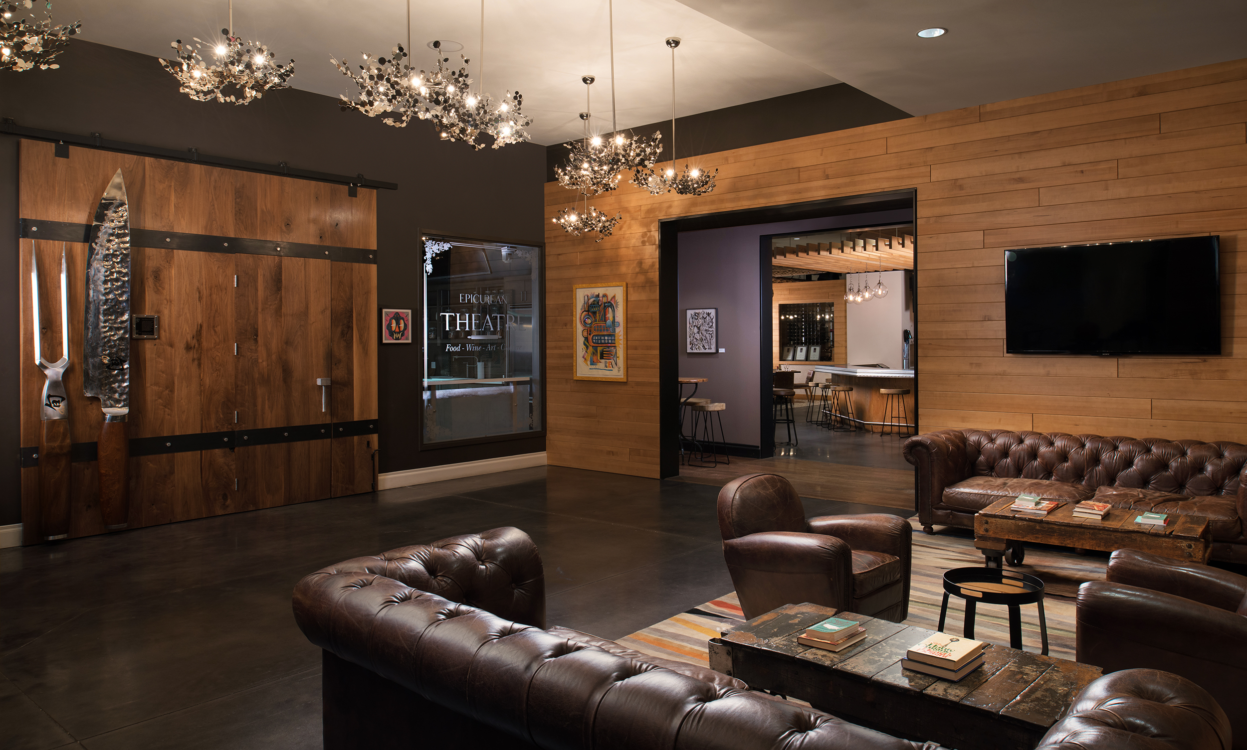 A room with leather couches and a chandelier