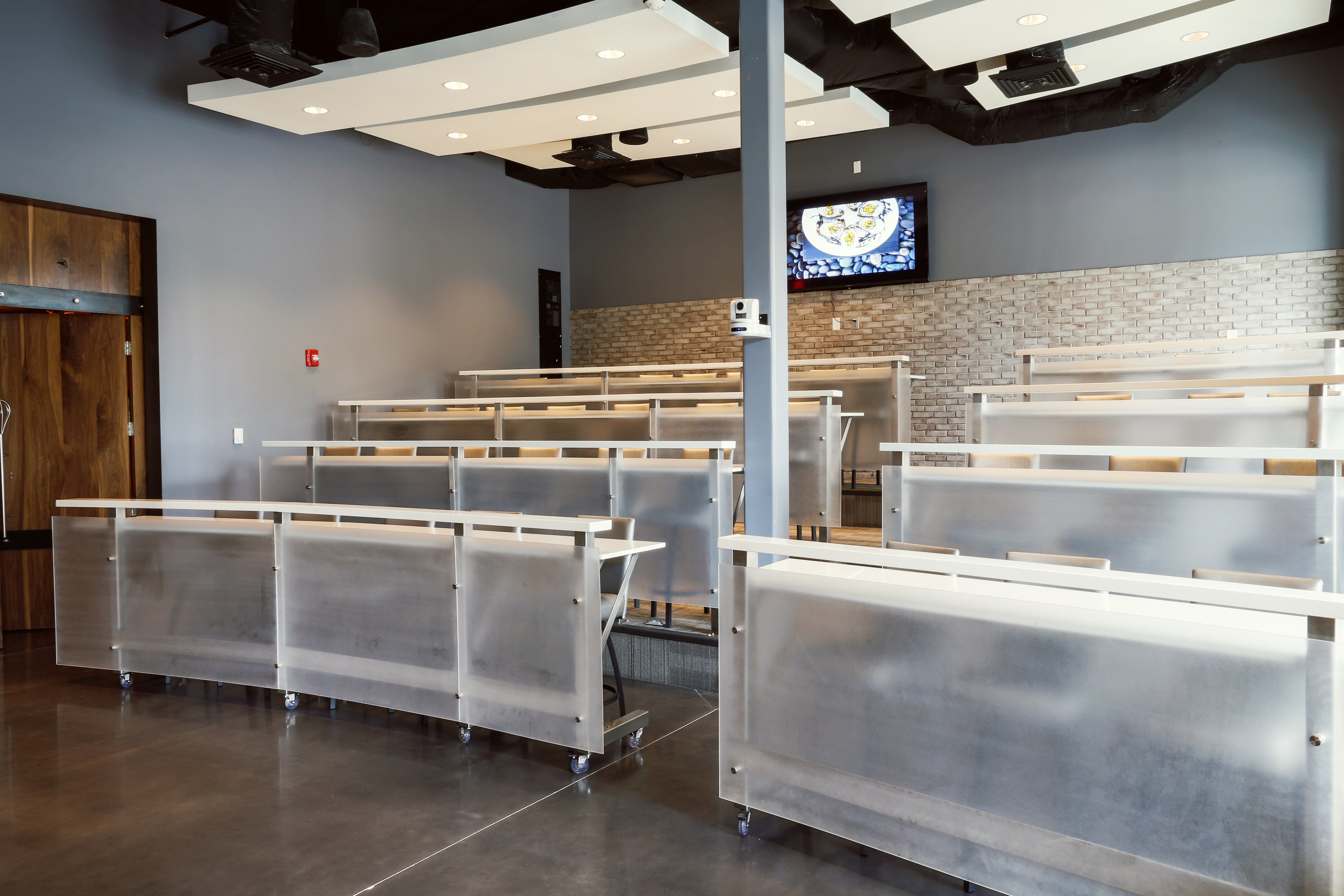 A room with stadium style seating and tables for culinary classes