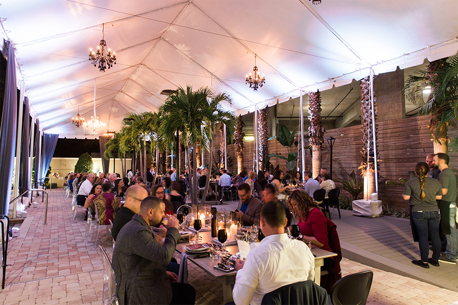 A group of people sitting at tables in a tent