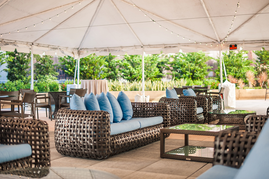 A patio with a white tent and furniture