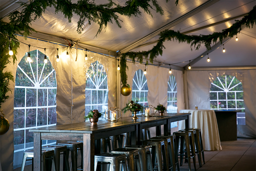 A table with stools and lights in a tent