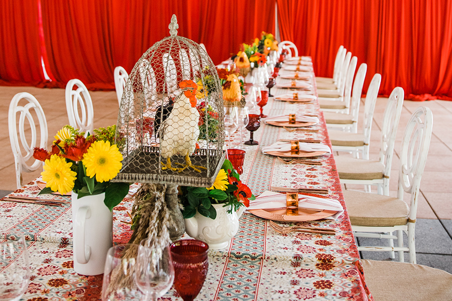 A long table with white chairs and flowers