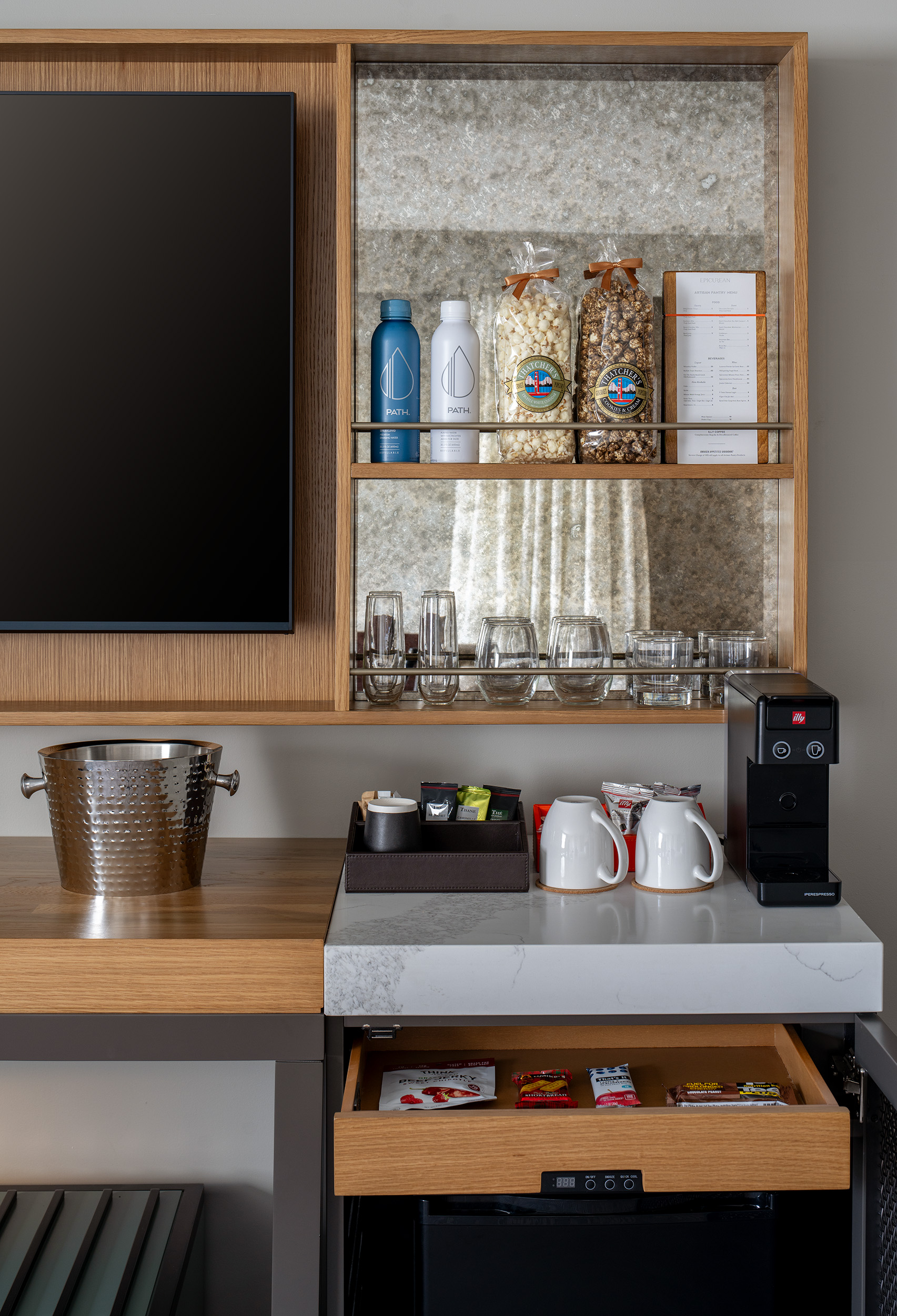 close up picture of hotel room artisan pantry with food and drink items, coffee maker and ice bucket