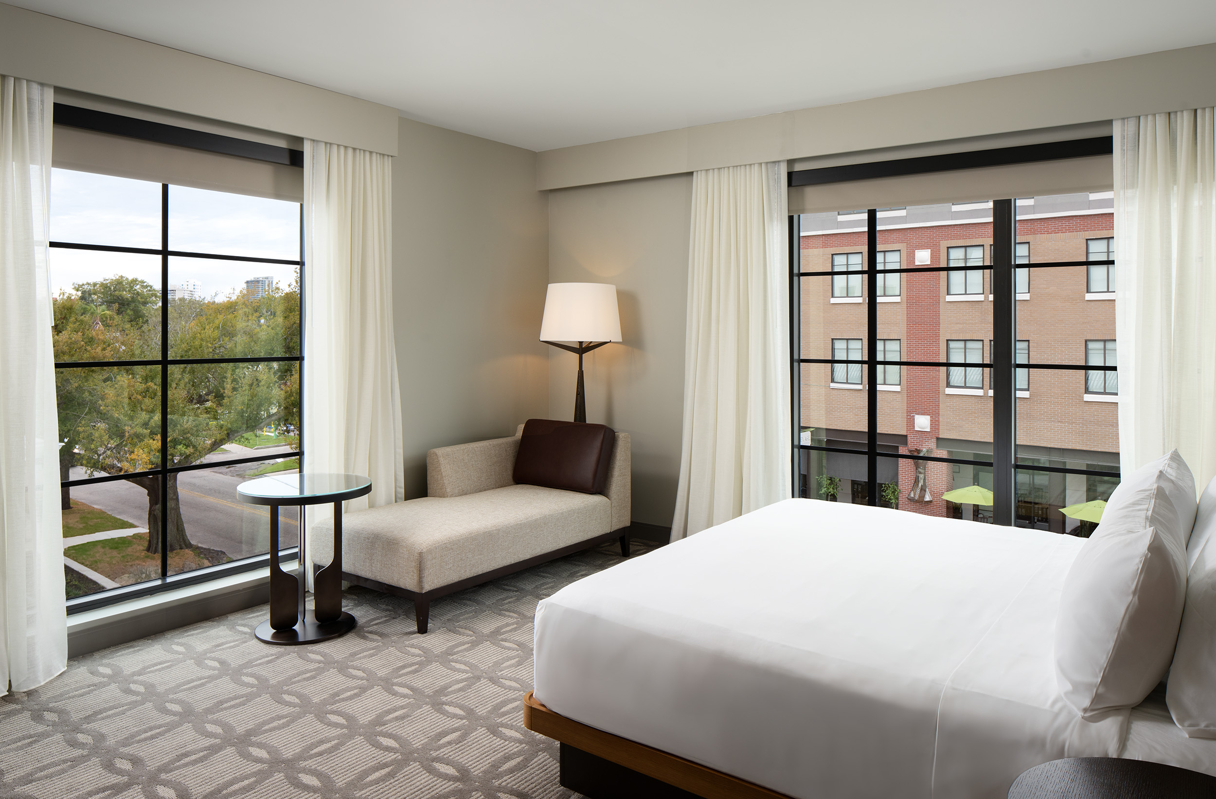 hotel guestroom with king bed and lounger for sitting