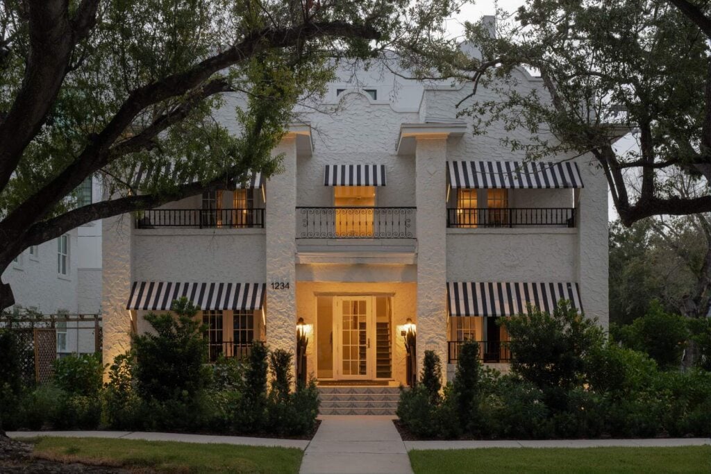 A historic hotel apartment building exterior at dusk across from Epicurean Hotel in Hyde Park District of South Tampa Florida