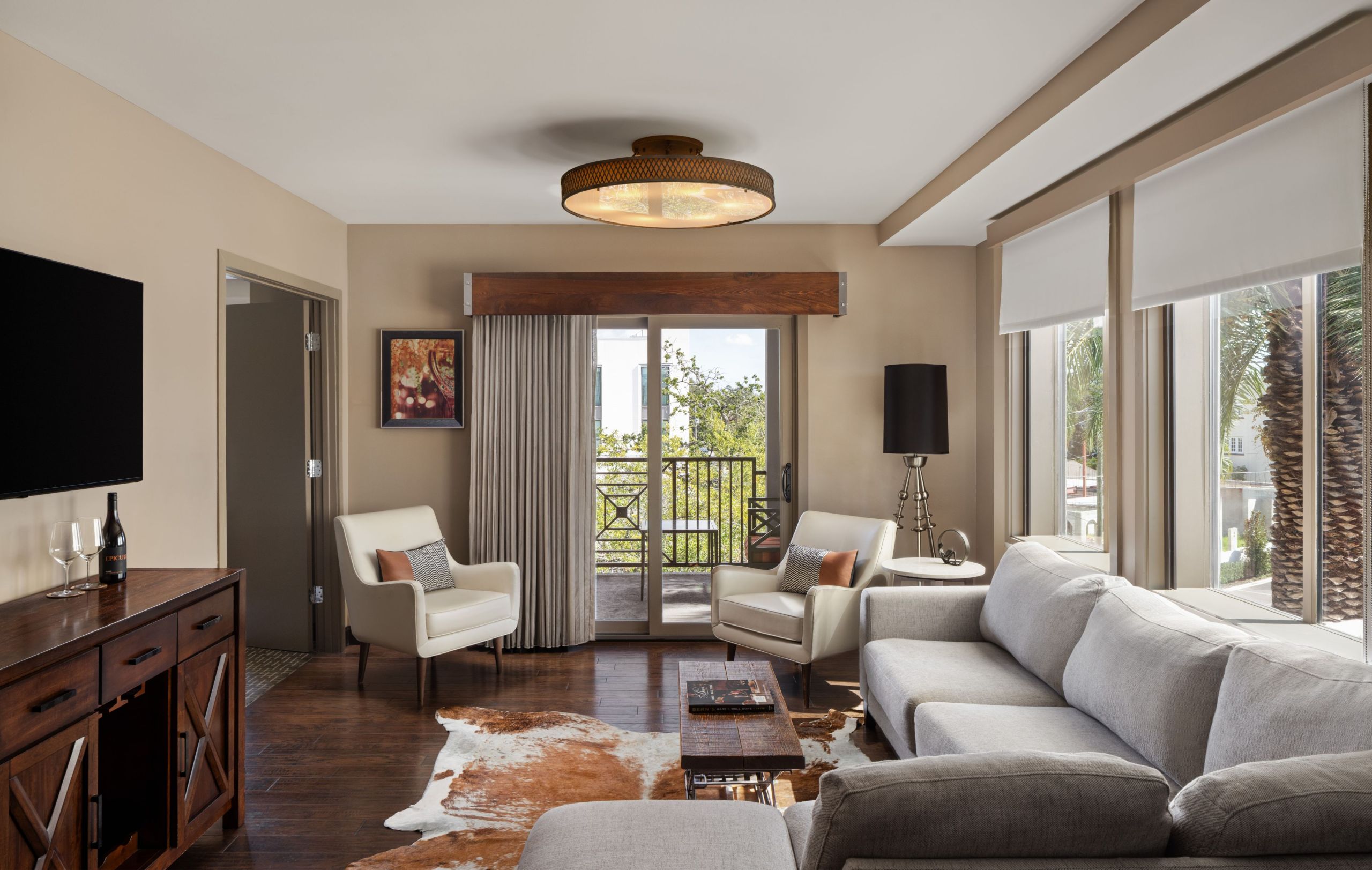 a hotel suite living room with view out towards a balcony at Epicurean Hotel in South Florida